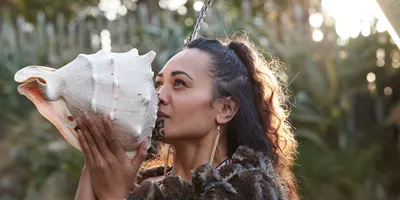 Maori Woman Blowing Into a Shell