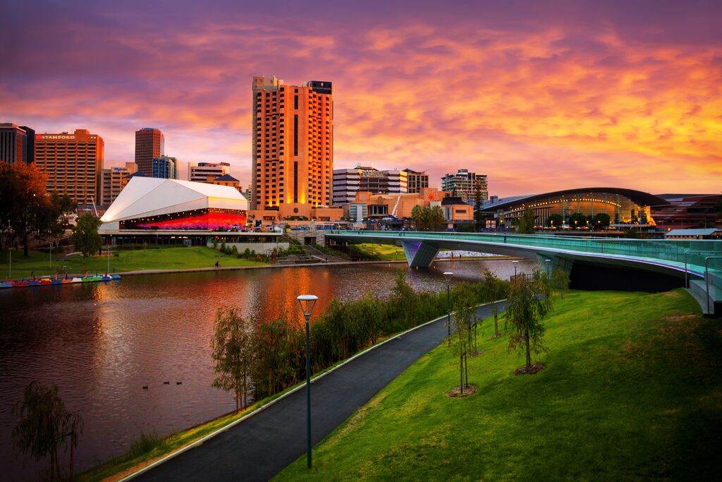 A city skyline with a bridge over a river with Sunset View Of Elder Park